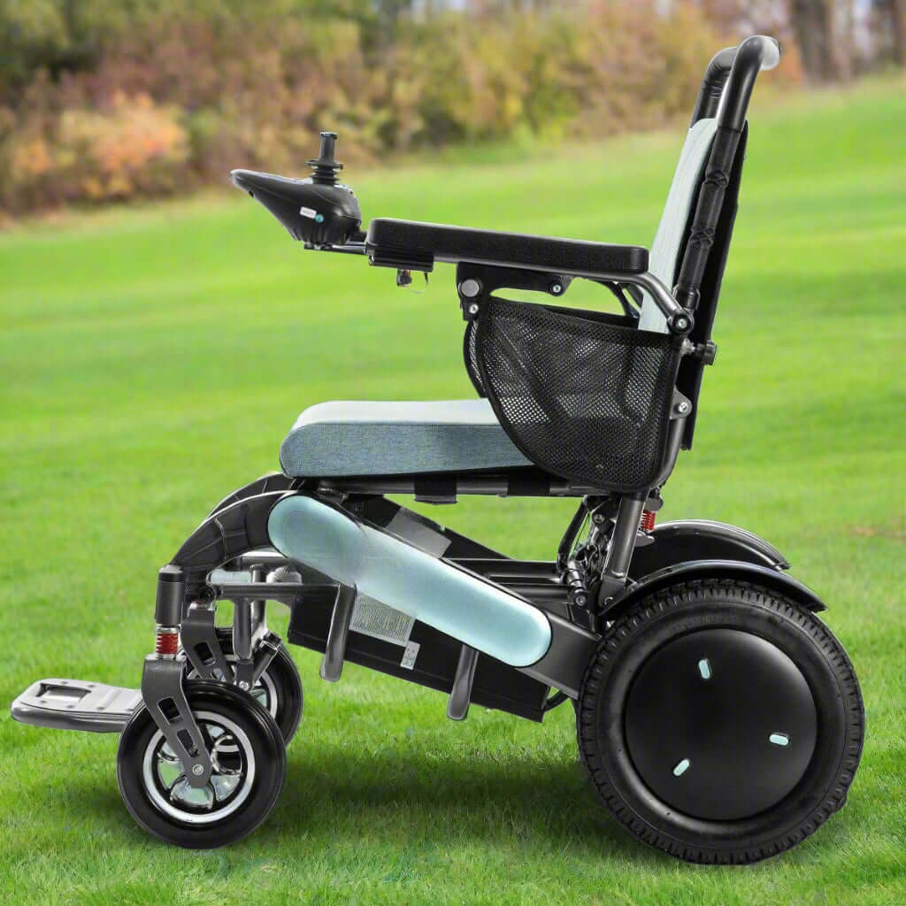 Side view of the 2024 MW9000UP Electric Wheelchair navigating a grassy terrain, demonstrating its all-terrain capability with six shock-absorbing springs and dual 600W motors.