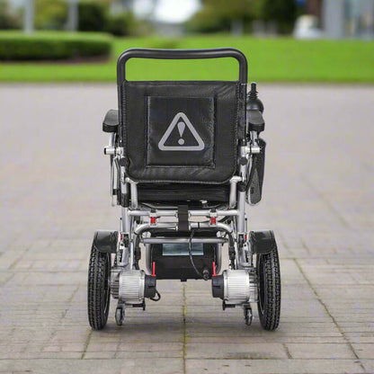 Rear view of the wheelchair showing anti-tip wheels and compact frame structure for stability and safety.